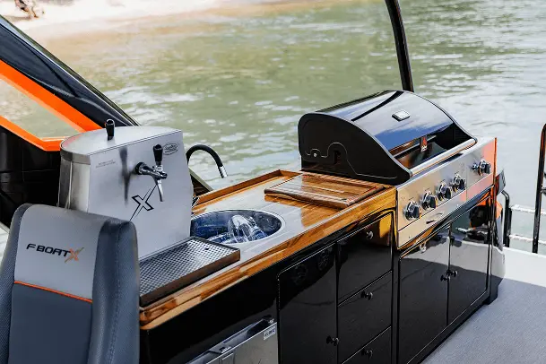 Área gourmet do F-Boat 9500 X, com churrasqueira e bancada